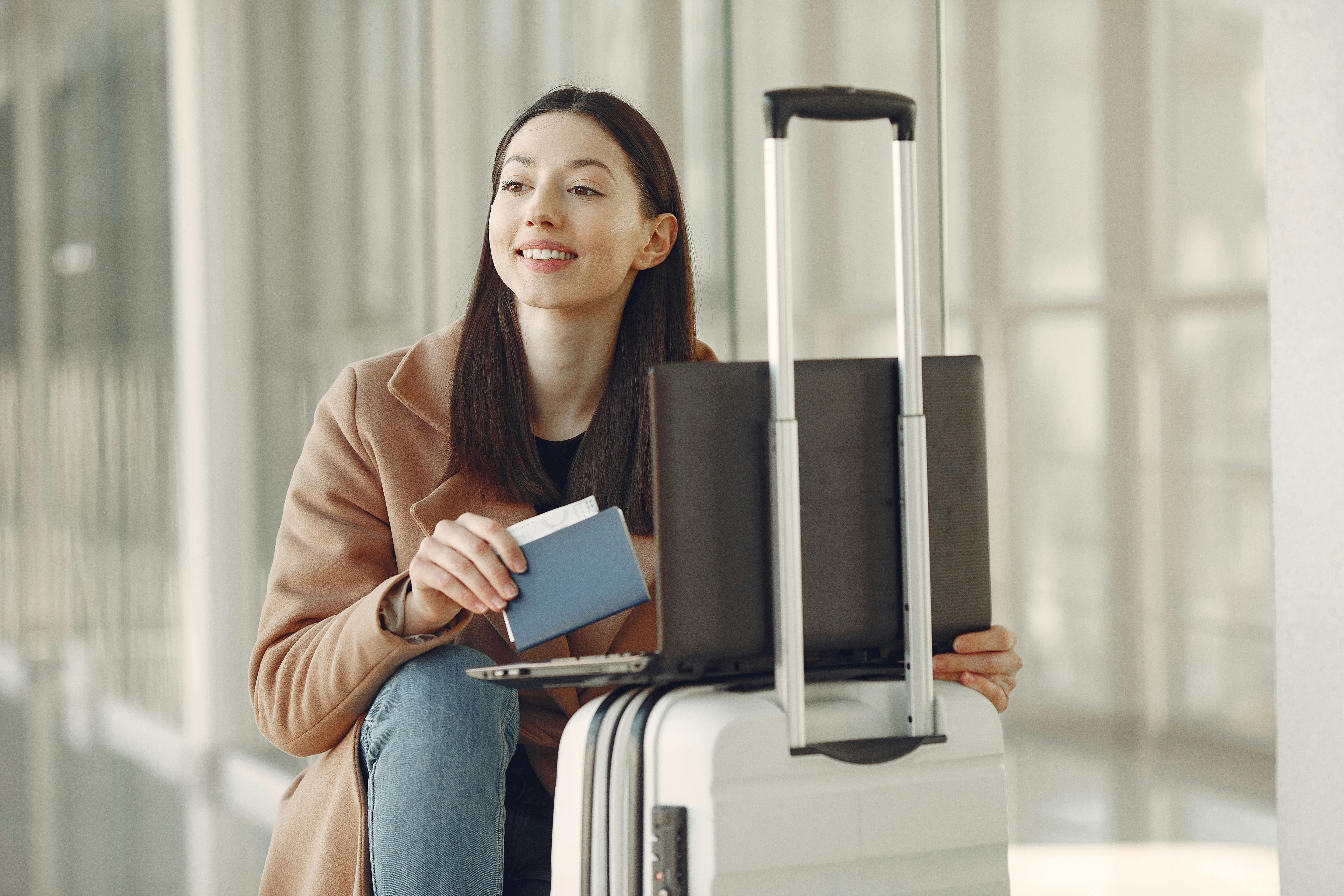 Woman holding passport near suitcase